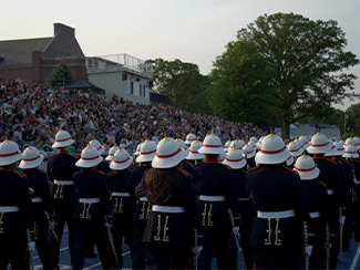 Student band dressed in uniform performing.